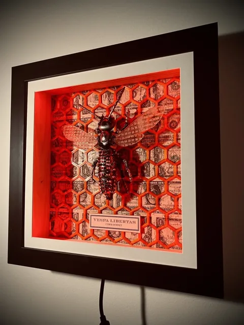 The framed sculpture illuminated in red.